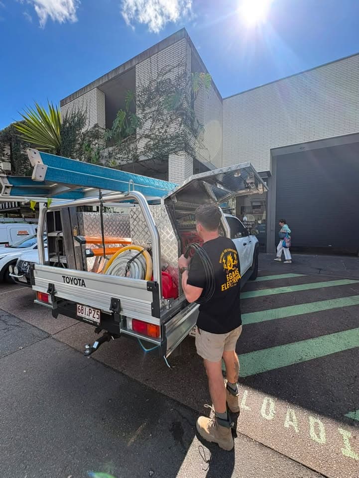 Egans Electrical ute loading cable outside a Brisbane strata building